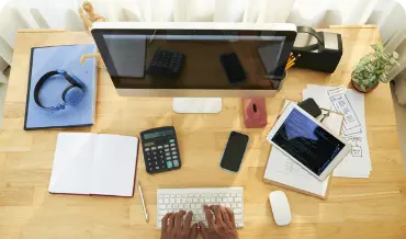 Individual engaged in typing on a computer and using a phone, highlighting custom solutions in cake PHP web development.