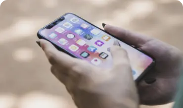 A person holding an iPhone he is CakePHP development services, showcasing the latest technology in a modern setting, perfect for tech enthusiasts.